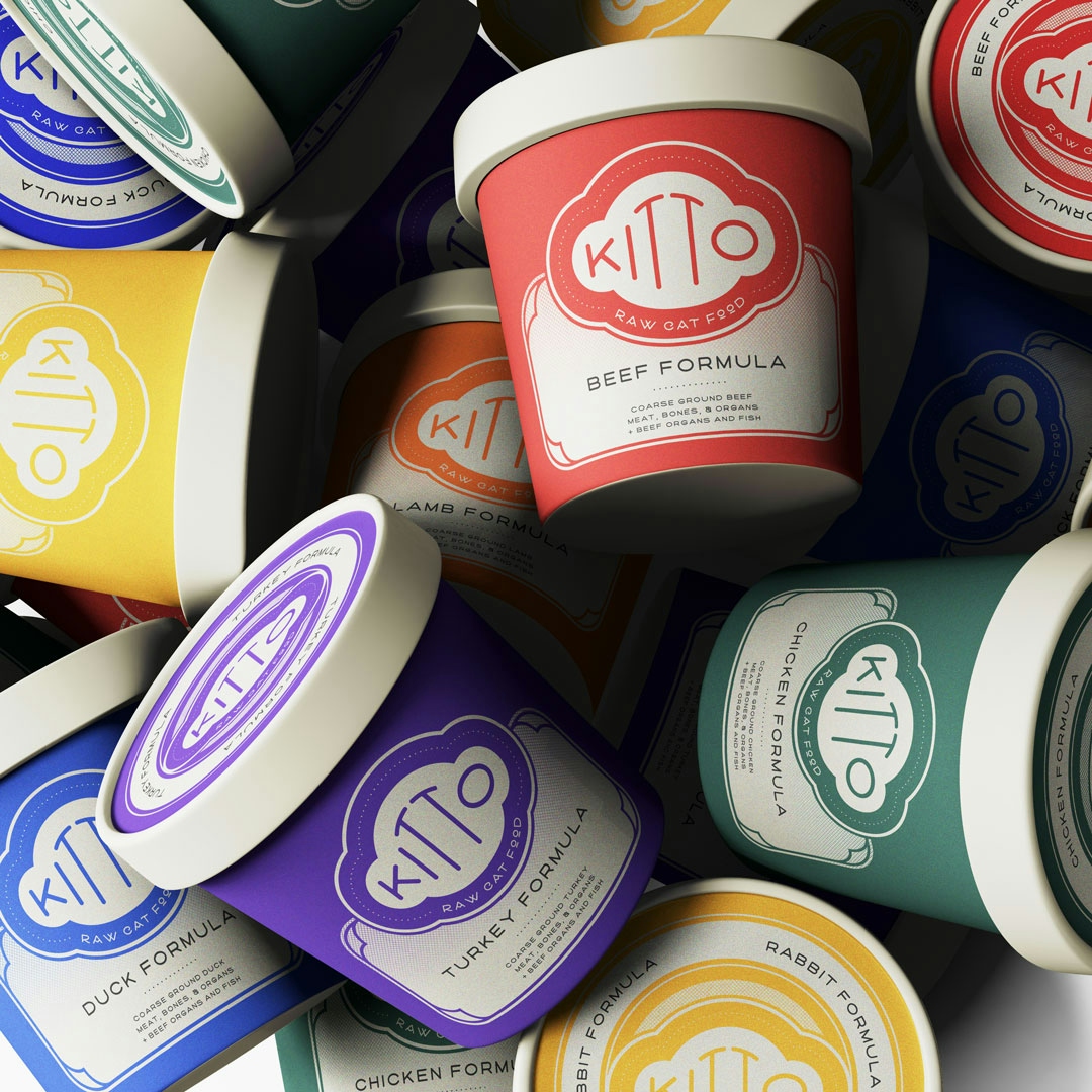 A pile of colorful branding and packaging for a raw cat food brand named Kitto.